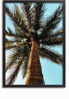 Een Palmboom Bij Heldere Hemel Schilderij van CollageDepot, perfect als wanddecoratie, toont het uitzicht terwijl je omhoog kijkt naar een hoge palmboom tegen een helderblauwe lucht. Het beeld legt de textuur vast van de boomstam en de uitgestrekte palmbladeren die naar buiten uitstralen. Ideaal voor display middels een magnetisch ophangsysteem.