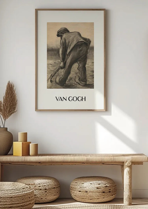 Een ingelijst CollageDepot Van Gogh Boer Schilderij hangt aan een witte muur boven een houten bank. De bank heeft eronder drie geweven ronde kussens en aan één kant decoratieve items waaronder een vaas met gedroogde planten en gestapelde kaarsen. Zonlicht werpt schaduwen op de muur en de bank.,Lichtbruin