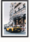 Een ingelijst Gele Lamborghini SVJ-schilderij van CollageDepot toont een gele sportwagen met een op maat gemaakt kenteken "SVJ JET", geparkeerd voor een groots gebouw met sierlijke architectuur. Verschillende mensen op de stoep bewonderen de auto, terwijl op de achtergrond palmbomen en extra gebouwen zichtbaar zijn. Perfect voor wanddecoratie!,Zwart-Met,Lichtbruin-Met,showOne,Met