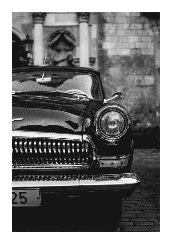 CollageDepot's aaa 062 - auto's, een zwart-witfoto van een oldtimer geparkeerd naast een oud stenen gebouw, met de glimmende grille en ronde koplamp van de auto. Het kenteken van de auto is zichtbaar.-