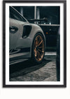 Een ingelijste foto van een Porsche GT3 RS met de focus op het achterwiel en metallic goudkleurige velgen. In deze donkere, mogelijk nachtelijke omgeving is een deel van de achtervleugel zichtbaar, wat het strakke design en de details van de auto benadrukt. Perfecte wanddecoratie met een magnetisch ophangsysteem voor eenvoudige presentatie. Het opvallende Porsche GT3 RS Schilderij van CollageDepot is een opvallende toevoeging aan elke kamer.,Zwart-Met,Lichtbruin-Met,showOne,Met