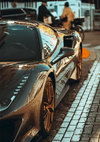 Een close-up van een CollageDepot AAA 068 - auto's geparkeerd in een stadsstraat, met gedetailleerde ontwerpen op de carrosserie en gouden wielen, met voetgangers op de achtergrond.-