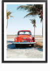 Een ingelijste foto van een vintage rode auto geparkeerd vlakbij een strand. De auto is van achteren gezien, waarbij het kenteken en het klassieke ontwerp zichtbaar zijn. Op de achtergrond zijn er palmbomen en de oceaan onder een helderblauwe lucht: een perfect stukje wanddecoratie met een magnetisch ophangsysteem voor eenvoudige weergave. Dit is het vintage Dominicaanse schilderij van CollageDepot.,Zwart-Met,Lichtbruin-Met,showOne,Met