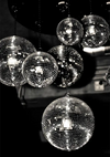 Verschillende ab 033 - zwart-wit discobollen van verschillende afmetingen hangen aan een plafond en reflecteren licht met een monochroom effect. (Merknaam: CollageDepot)-