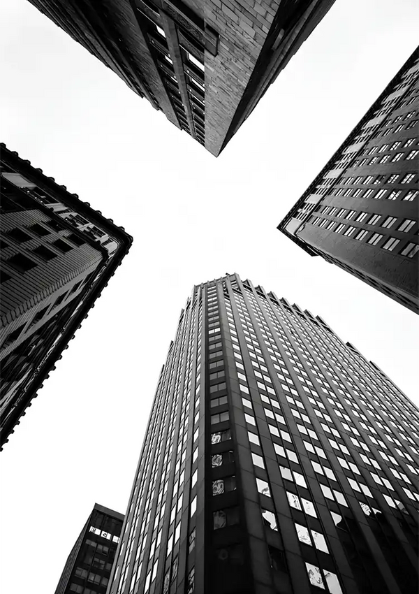 ab 057 - zwart-witfoto genomen vanuit een lage hoek, waarop drie hoge gebouwen te zien zijn die naar de hemel convergeren en hun architectonische details en ramen benadrukken.-