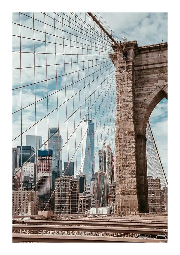 Een Uitzicht Skyline New York Schilderij van CollageDepot met de stenen bogen en metalen kabels, met een achtergrond van wolkenkrabbers in Manhattan onder een gedeeltelijk bewolkte hemel. Tussen de gebouwen is het One World Trade Center prominent aanwezig.-