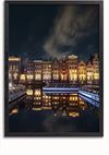 Een nachtelijk tafereel van een kanaal met rivierboten aangemeerd voor een rij verlichte, traditionele Amsterdamse grachtenpanden, weerspiegeld in het water. De lucht is donker met enkele verspreide wolken, waardoor een betoverend Amsterdamse Grachtenpanden Schilderij van CollageDepot ontstaat.,Lichtbruin