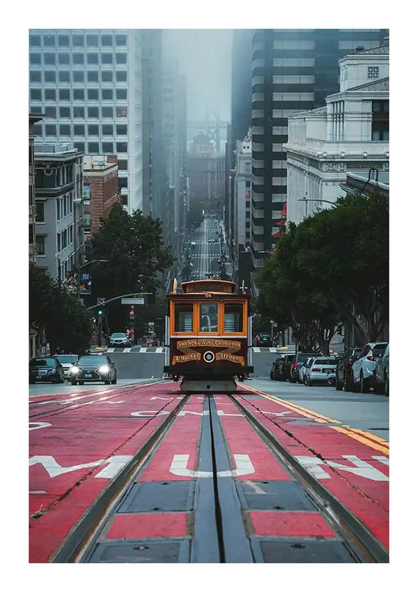 Een CollageDepot baa 034 - landen en steden rijdt door een steile straat in San Francisco met zichtbare roodgeverfde rails. Gebouwen omzomen de mistige straat die overgaat in de mistige achtergrond.-