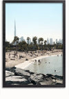 Een zonnig strandtafereel met mensen die zwemmen en ontspannen. Palmbomen omzomen de kust en de skyline van Dubai, inclusief de hoge, opvallende toren, is op de achtergrond zichtbaar. Op de voorgrond zijn grote rotsen aan de waterkant te zien. Dit levendige uitzicht zou een prachtig Skyline Dubai Schilderij van CollageDepot vormen.,Zwart-Zonder,Lichtbruin-Zonder,showOne,Zonder