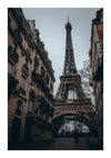 Een zicht op de Eiffeltoren vanuit een smalle straat vol hoge, oude gebouwen. De lucht is bewolkt en kale bomen flankeren de toren. Twee mensen lopen over de geplaveide straat richting de toren in de verte, alsof ze een CollageDepot Smalle Straat Eiffeltoren Schilderij binnenstappen, perfect voor wanddecoratie.-