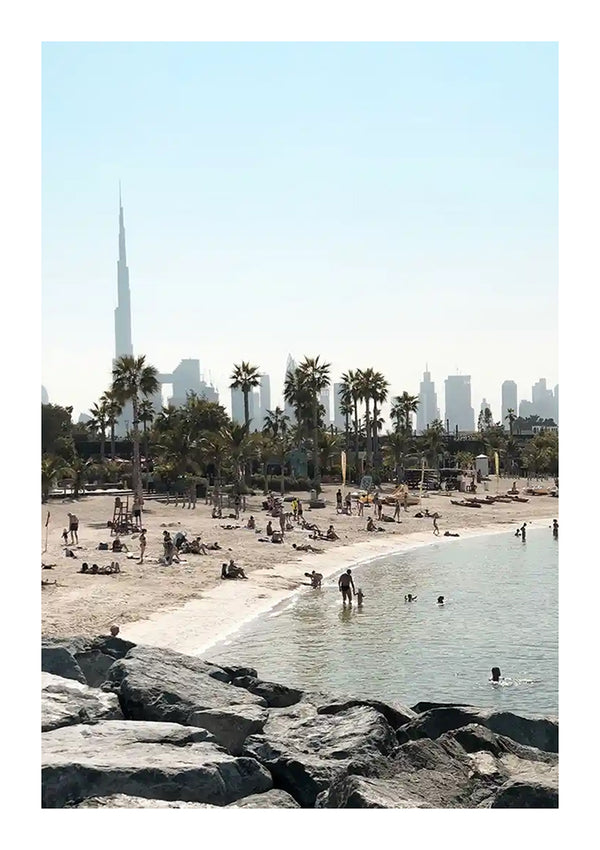 Een schilderachtig strand met mensen en palmbomen, met uitzicht op de skyline van de stad met een prominente wolkenkrabber op de achtergrond, onder een heldere hemel gecreëerd door CollageDepot's baa 063 - landen en steden.-