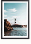 Een ingelijste foto van de Golden Gate Bridge tegen een helderblauwe lucht. De brug wordt getoond over een watermassa met rotsachtig terrein op de voorgrond aan de linkerkant. Het frame heeft een glanzend zwarte afwerking. Dit is de bbb 005 - natuur van CollageDepot.,Zwart-Met,Lichtbruin-Met,showOne,Met