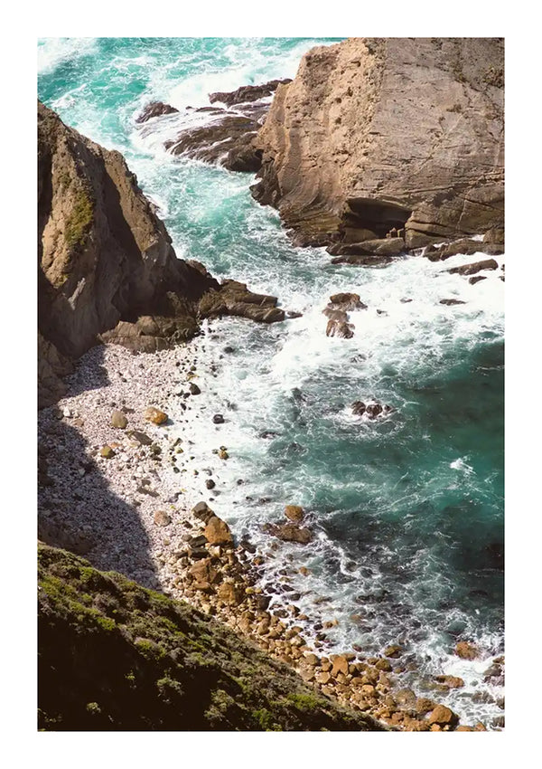 Luchtfoto van een ruige kustlijn met turquoise golven die tegen scherpe kliffen en rotsachtige kusten beuken, geaccentueerd door stukjes groene vegetatie uit CollageDepot's cc 074 - natuur.-
