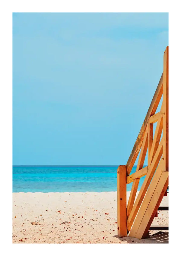 Een levendig beeld met een deel van een oranje houten trap op een zandstrand, dat leidt naar een helder turquoise zee onder een blauwe lucht. Deze afbeelding komt uit de collectie cc 084 - natuur van CollageDepot.-