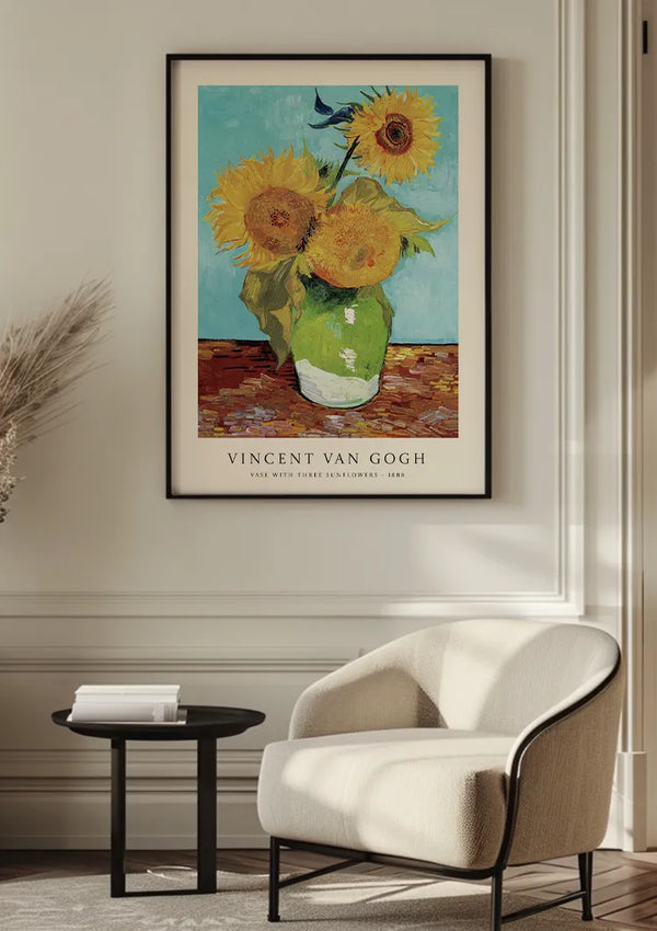 Een ingelijst CollageDepot V. Van Gogh Zonnebloemen Vaas Schilderij hangt aan een witte muur boven een beige fauteuil en een klein zwart rond tafeltje. De kamer beschikt over een neutraal kleurenpalet, een minimalistische inrichting en het schilderij is beveiligd met een elegant magnetisch ophangsysteem.,Zwart