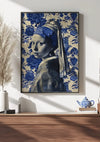 Aan een witte muur hangt een ingelijst kunstwerk met een blauw-witte weergave van het 'Meisje met de parel'. Daaronder staat een houten plank met decoratieve spullen, waaronder een potplant, een aab 336 Delfts blauw theepot van CollageDepot en een bijpassend theekopje.,Zwart