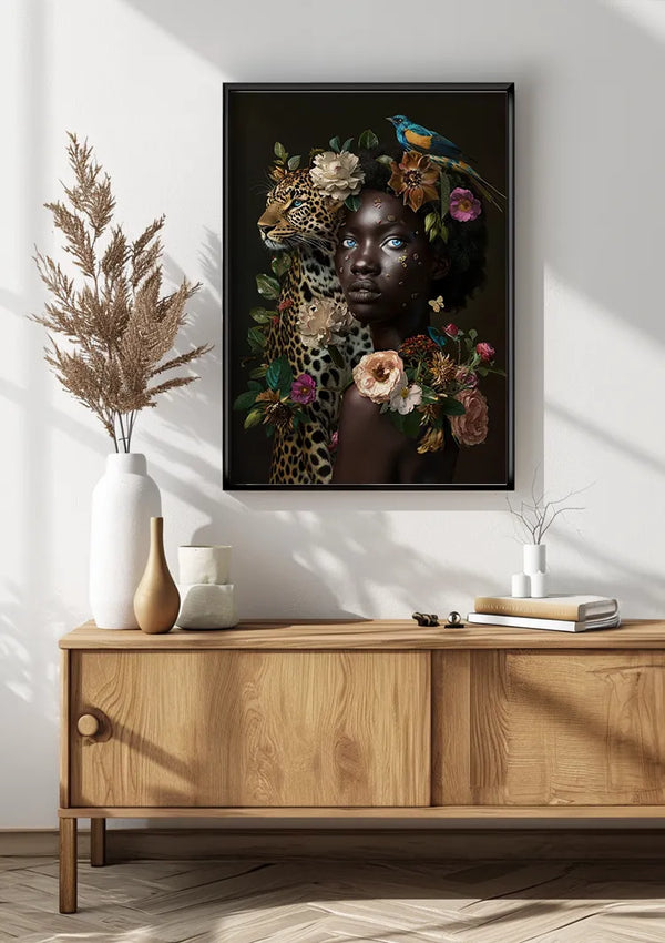 Aan een witte muur boven een houten dressoir hangt een ingelijst schilderij van een vrouw versierd met bloemen en bladeren, met daarop een luipaard en een vogel. Op het dressoir staan ook enkele siervazen en een plant. Zonlicht creëert schaduwen op de neutrale achtergrond, waardoor de serene sfeer van AAA 101 Exclusive by CollageDepot wordt versterkt.,Zwart