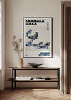 Een minimalistisch interieur bestaat uit een houten consoletafel tegen een witte muur met daarboven een ingelijste poster. Het K. Sekka Japanse vlinderschilderij van CollageDepot toont "Kamisaka Sekka", "Japanse vlinder", met twee blauwe vlinders. Gedroogde planten in een vaas en een zwarte schaal sieren de tafel, allemaal opgehangen met een magnetisch ophangsysteem.,Zwart