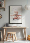 Een houten bureau en bijpassende kruk staan tegen een lichtgrijze muur. Boven het bureau hangt een Teddybeer In Roze Vliegtuig Schilderij van CollageDepot. Het bureau bevat enkele schrijfwaren en is omgeven door een minimalistisch decor, waaronder een hanglamp aan de rechterkant, die de charmante wanddecoratie versterkt.,Zwart