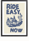 Een ingelijst CollageDepot Ride Easy Now Schilderij, perfect als wanddecoratie, toont de zinsnede "Ride Easy Now" in vetgedrukte, blauwe letters. Op de achtergrond is een monochrome blauwe illustratie te zien van een cowboy op een paard in een woestijnlandschap met cactussen en rotsformaties.,Zwart-Met,Lichtbruin-Met,showOne,Met