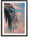 Een ingelijste foto toont het silhouet van palmbladeren tegen een pastelkleurige lucht met roze en blauwe tinten. Het serene, tropische beeld dient als perfecte wanddecoratie, aangevuld met een handig magnetisch ophangsysteem voor moeiteloze presentatie. Dit is het Palmblad Close Up Schilderij van CollageDepot.
