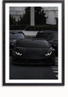 Een zwart op zwart Lamborghini-schilderij van CollageDepot is gecentreerd in de afbeelding, met de koplampen aan. Geflankeerd door twee andere donkergekleurde voertuigen in een stedelijke omgeving lijkt het tafereel op een sportwagenschilderij. De afbeelding is omlijst met een eenvoudige zwarte rand.,Zwart-Met,Lichtbruin-Met,showOne,Met